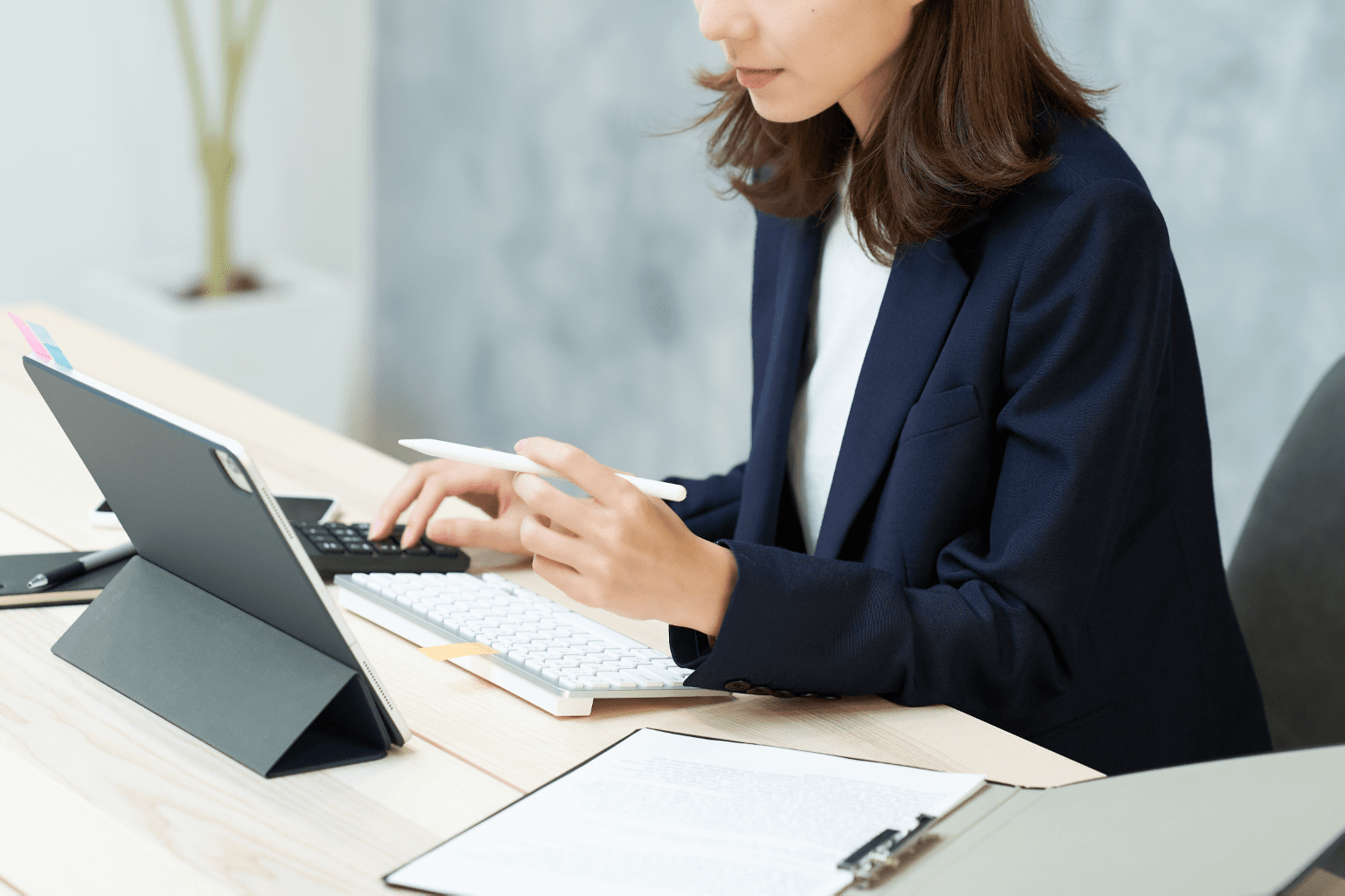 タブレットを使用して学習しているスーツの女性